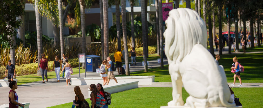 Students walking on campus around the LMU Lion Statue