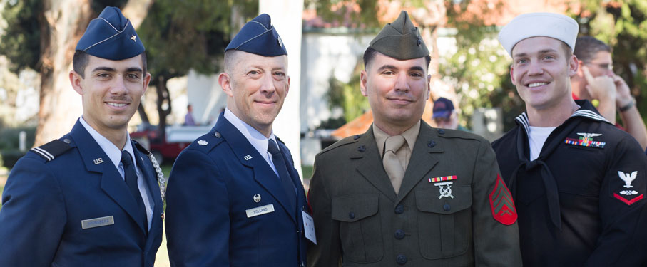 Four LMU veterans stand together in uniform.