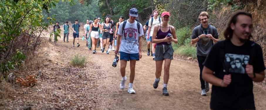 Students outside hiking on a dirt path.