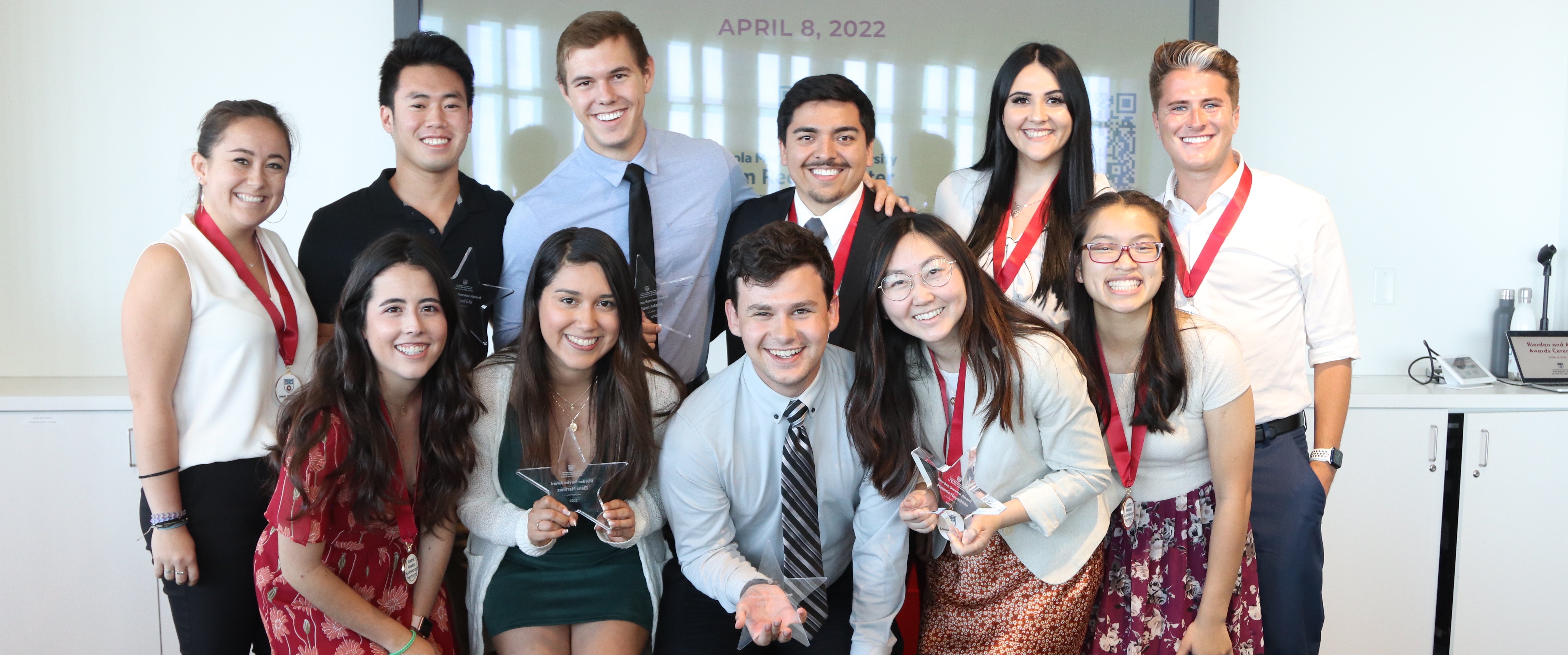 group of students holding their awards and smiling towards the camera