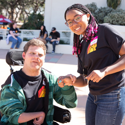 A student and local athlete pose outside on LMU's campus during the annual Special Games program.