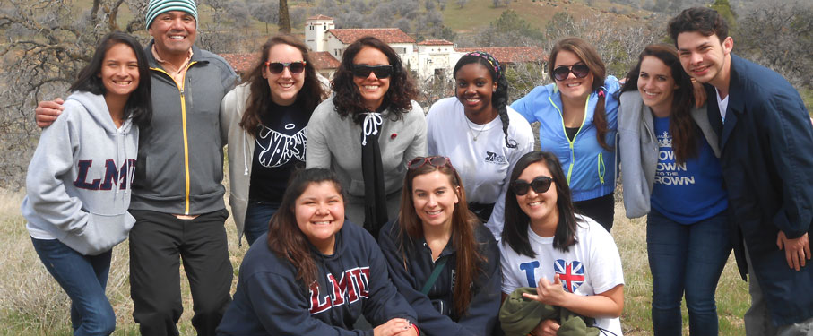 a group of eleven LMU students smiling during their Alternative Break trip 