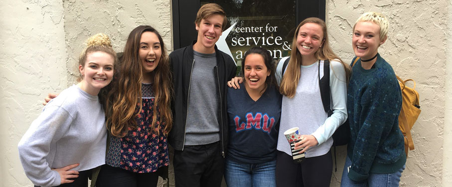six LMU students standing in front of the Center for Service and Action building.