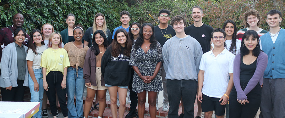 Students and staff gather in the backyard of the LMU houses during a fall dinner.