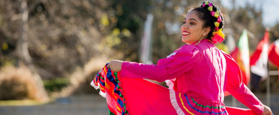 A student in GFLMU dances in a pink dress outside.