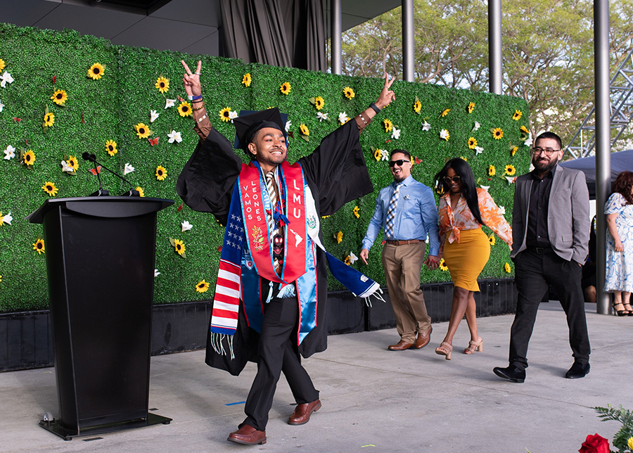 A student and his family walk across the stage celebrating during the annual Dia celebration.