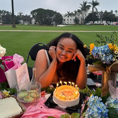 Metanya Zewdu poses on Sunken Garden with a birthday cake with candles.