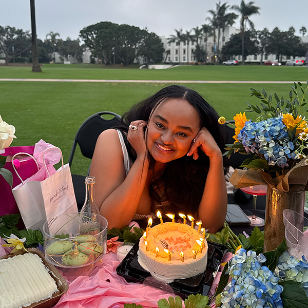 Metanya Zewdu poses on Sunken Garden with a birthday cake with candles.