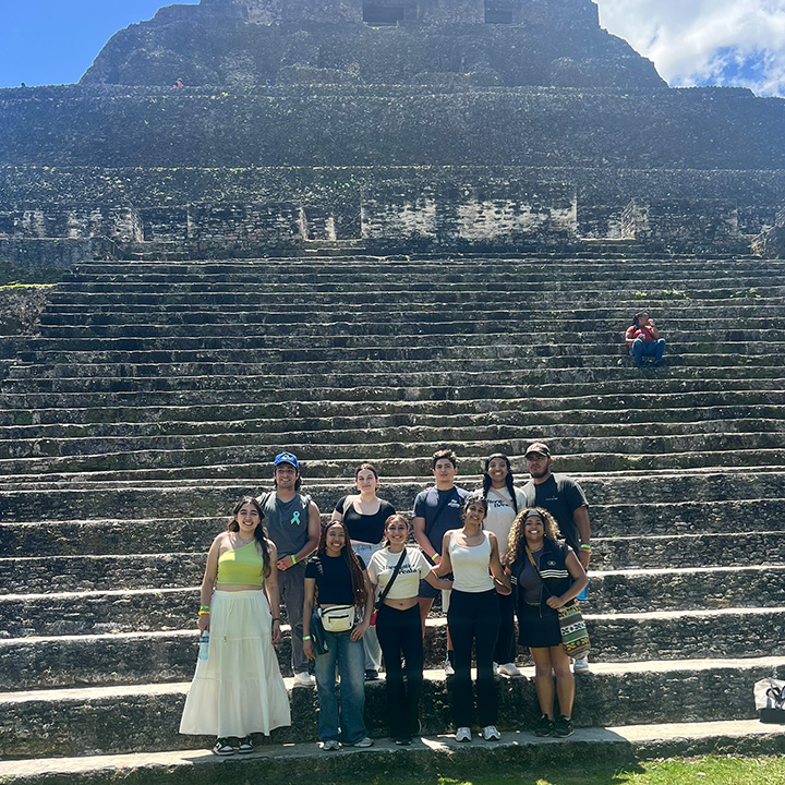 Students pose outside on the steps of ancient stone steps in Belize.
