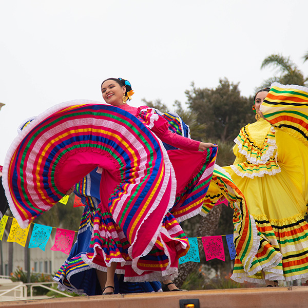 A student in a bright pink dress dances during the annual Sueno de Mexico event.