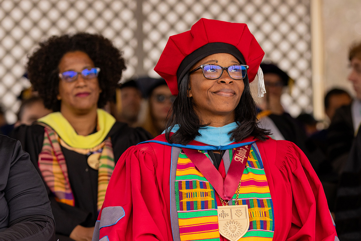 SVP Leggett sits in her crimson regalia at an LMU Commencement event looking upward.