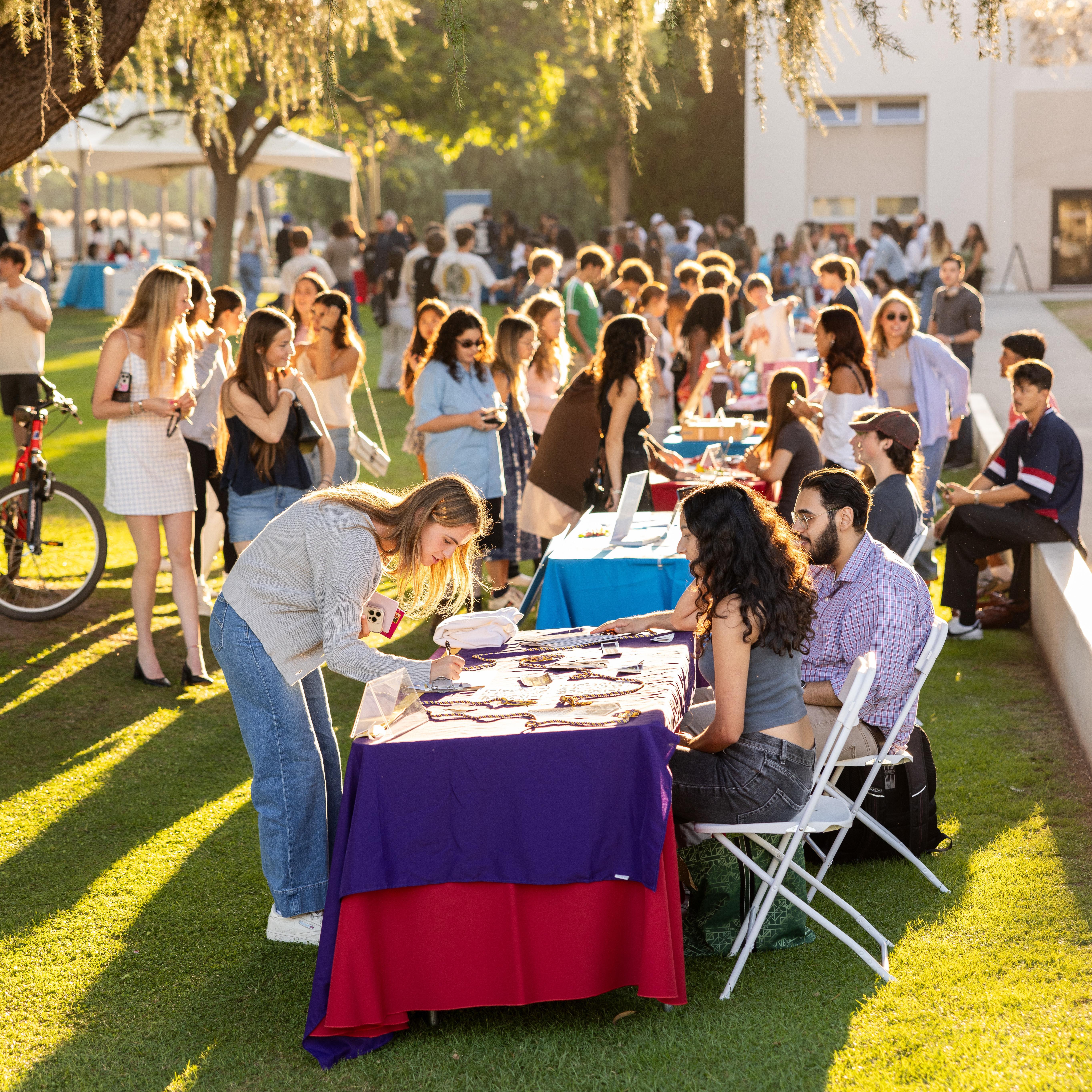 Students gather at a table outside to learn about involvement opportunities.