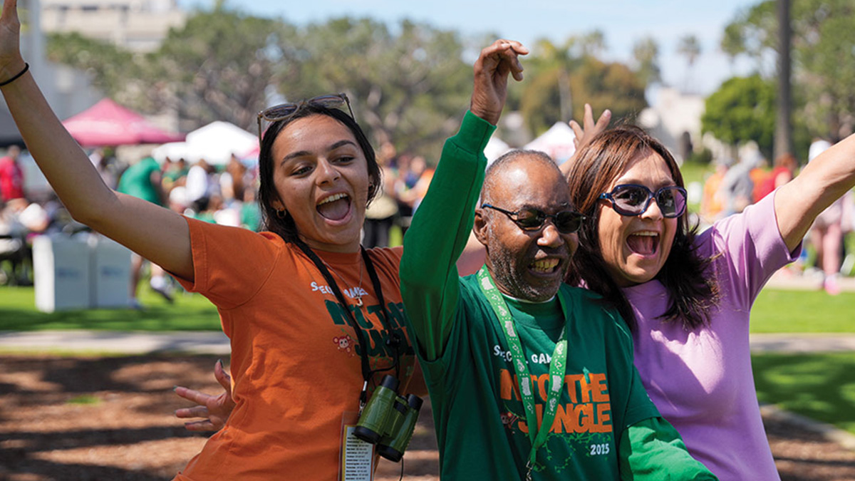 A student, alum, and athlete pose cheering outside during the 2025 LMU Special Games.