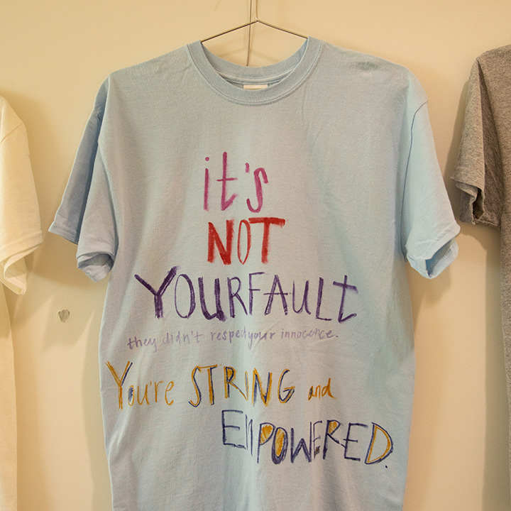A photo of a blue T-shirt hanging on a clothesline explaining the Clothesline Project