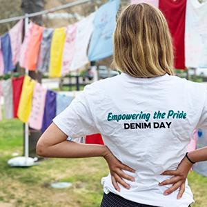 A female student poses outside in front of the Clothesline Project
