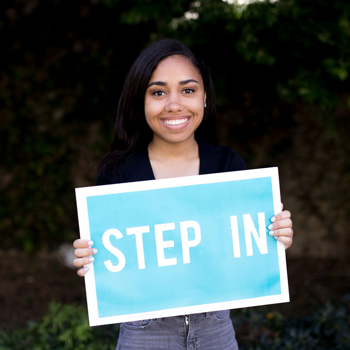 A student holding a sign that reads