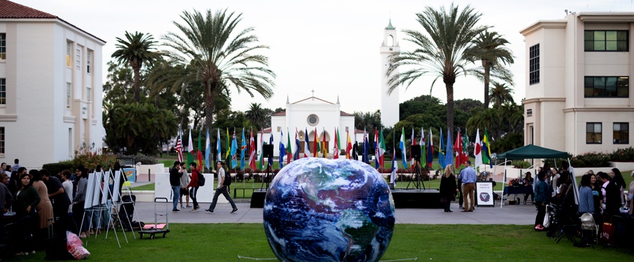 A giant blow-up globe in front of country flags.