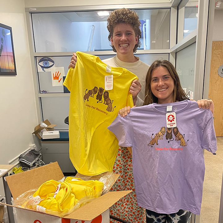 Students standing at table promoting Lions for Recovery