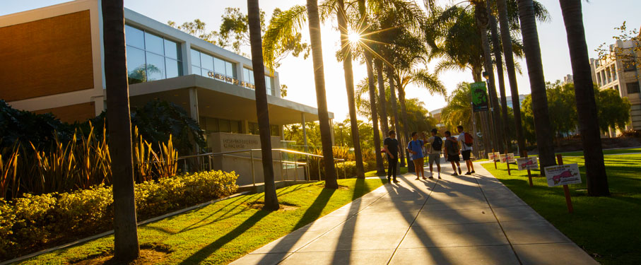 LMU Students walking by the Von Der Ahe building as the sun sets.