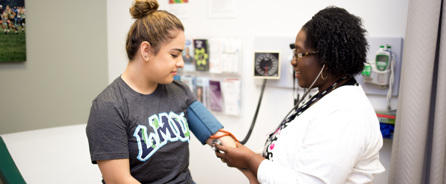 lmu student health services staff checking lmu student's blood pressure in doctor's office