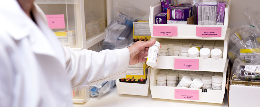 lmu shs student health services staff member reviewing prescription bottles and prices