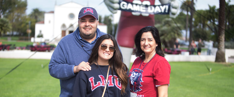 Family of three standing on Alumni Mall