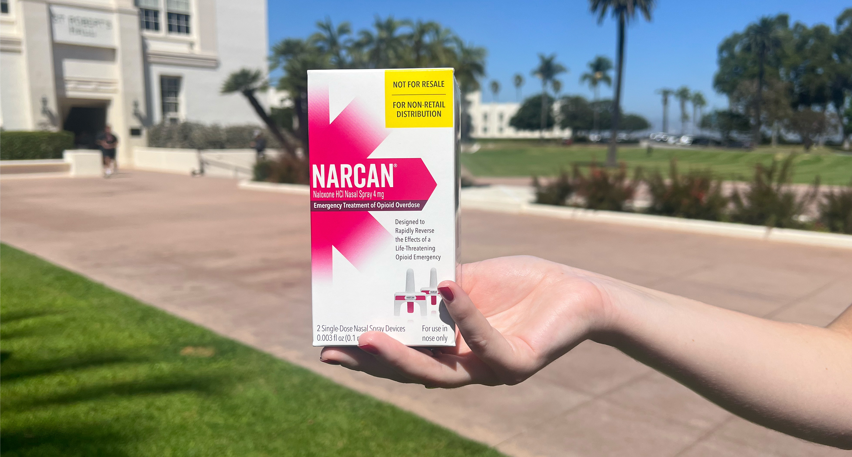 A student holds a box of naloxone outside at LMU.
