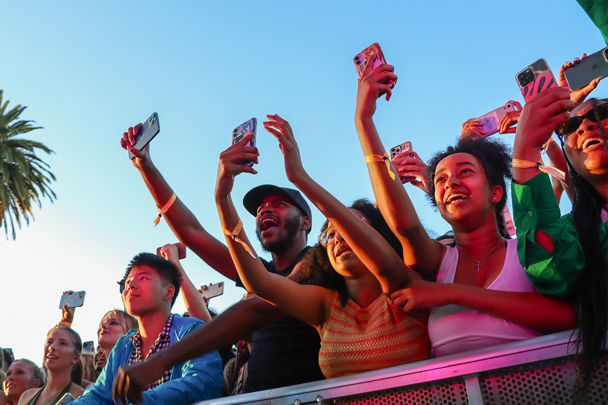 Students stand in the crowd watching a performer on the stage during the 2022 Fallapalooza.